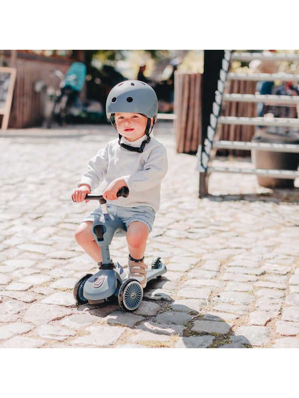Scoot and Ride - Highwaykick 1 - Steel: Kind op step met helm, speelt op cobblestone in de buitenlucht.